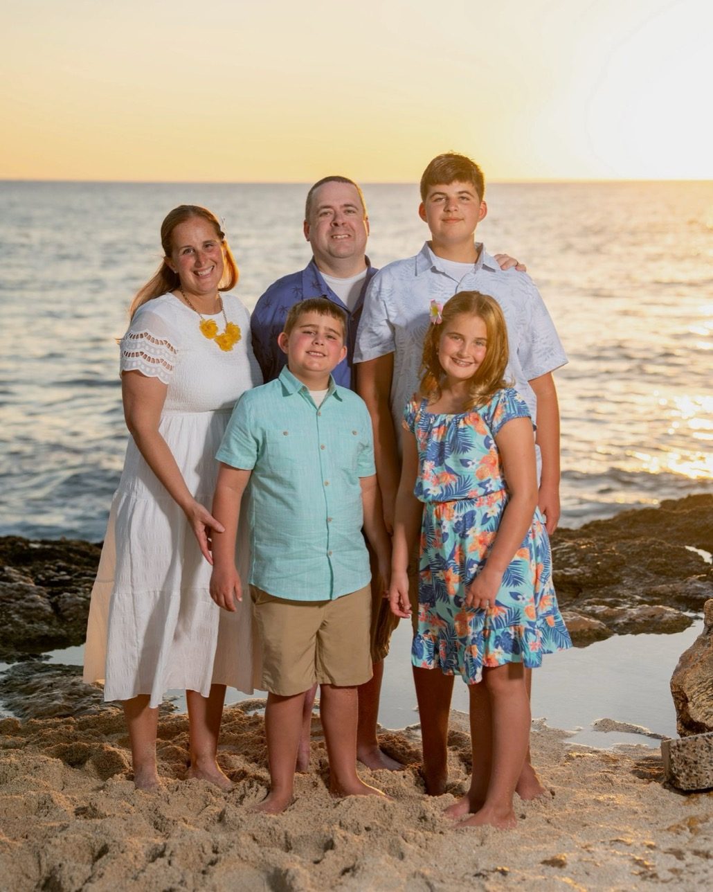 Melanie Francis with her husband and three children on the beach at sunset